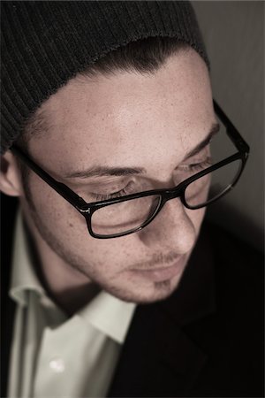 eyesight - Close-up, High Angle View of Young Man wearing Woolen Hat and Eyeglasses, Studio Shot Stock Photo - Premium Royalty-Free, Code: 600-06486245