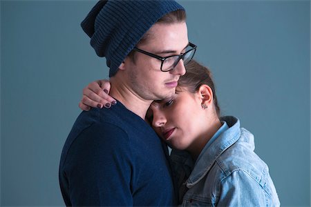 emotional attachment - Close-up Portrait of Young Couple Embracing, Studio Shot on Blue Background Stock Photo - Premium Royalty-Free, Code: 600-06486269
