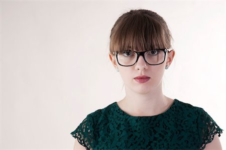 Head and Shoulder Portrait of Young Woman wearing Horn-rimmed Eyeglasses, Looking at Camera, Studio Shot on White Background Foto de stock - Sin royalties Premium, Código: 600-06486273