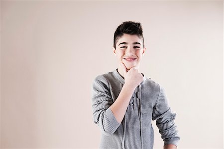 Waist up Portrait of Boy with Hand on Chin in Studio Stock Photo - Premium Royalty-Free, Code: 600-06486393