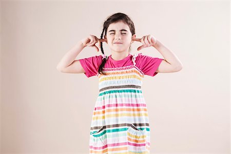 female dress white background - Portrait of Girl with Eyes Closed and Fingers in Ears in Studio Stock Photo - Premium Royalty-Free, Code: 600-06486415