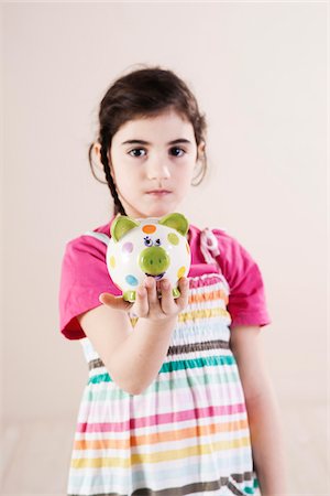 Portrait of Girl holding Piggy Bank in Studio Photographie de stock - Premium Libres de Droits, Code: 600-06486428