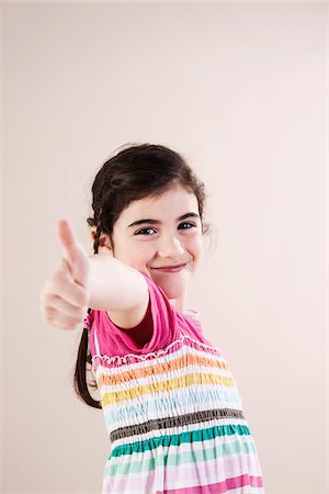 Portrait of Girl giving Thumbs Up in Studio Photographie de stock - Premium Libres de Droits, Code: 600-06486422