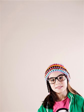 Portrait of Girl wearing Woolen Hat and Horn-rimmed Eyeglasses, Smiling at Camera, Studio Shot Stock Photo - Premium Royalty-Free, Code: 600-06505877