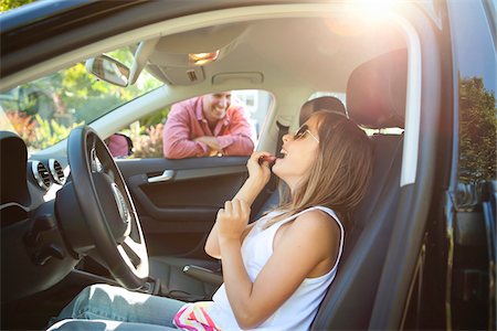 Young girl applying Lip Gloss, pretending to be old enough to drive as her smiling father watches on on a sunny summer evening in Portland, Oregon, USA Photographie de stock - Premium Libres de Droits, Code: 600-06531442