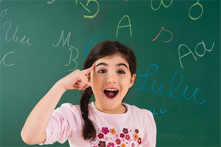 elementary classroom students - Portrait of Girl in Front of Chalkboard in Classroom Stock Photo - Premium Royalty-Free, Code: 600-06543496