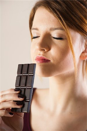 smelling - Close-up of Teenage Girl holding Chocolate with Eyes Closed, Studio Shot on White Background Photographie de stock - Premium Libres de Droits, Code: 600-06553411