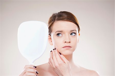 simsearch:400-04604807,k - Head and Shoulders Portrait of Teenage Girl Looking in Mirror in Studio Stock Photo - Premium Royalty-Free, Code: 600-06570927