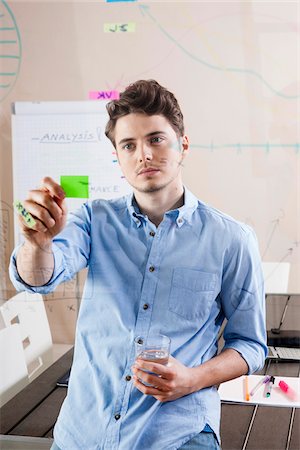 drawing (visual aid) - Young Man Working in an Office, Looking Through Glass Board, Germany Stock Photo - Premium Royalty-Free, Code: 600-06620957