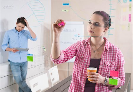 drawing (visual aid) - Young Man and Young Woman Working in an Office, Looking Through Glass Board, Germany Stock Photo - Premium Royalty-Free, Code: 600-06620951