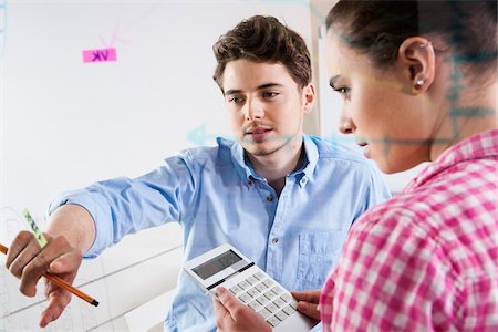 drawing (visual aid) - Young Man and Young Woman Working in an Office, Looking Through Glass Board, Germany Stock Photo - Premium Royalty-Free, Code: 600-06620960