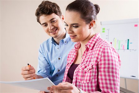 report (written account) - Young Businessman and Young Businesswoman Reading Document in Office Stock Photo - Premium Royalty-Free, Code: 600-06620991