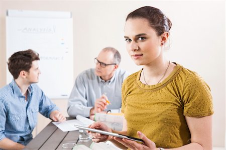 Portrait of Young Businesswoman holding Tablet with Colleagues Meeting in the Background Foto de stock - Sin royalties Premium, Código: 600-06621002