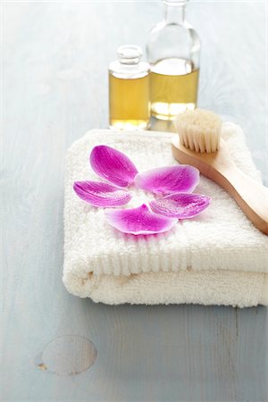 Orchid petals on a towel, brush, bottles of oil, wellness Stock Photo - Premium Royalty-Free, Code: 600-06675028