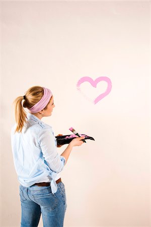 painting - Studio Shot of Young Woman Painting Heart on Wall Stock Photo - Premium Royalty-Free, Code: 600-06671768