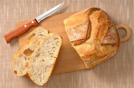 Overhead View of Bread on Cutting Board with Knife Stock Photo - Premium Royalty-Free, Code: 600-06671812