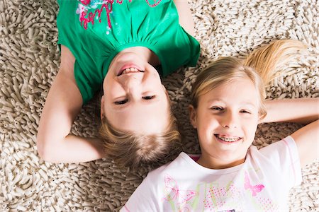 simsearch:600-06685178,k - Overhead View of Girls lying on Carpet in Studio Photographie de stock - Premium Libres de Droits, Code: 600-06685175