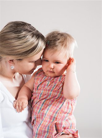 personal - Portrait of Mother holding Crying Baby Girl, Studio Shot Stock Photo - Premium Royalty-Free, Code: 600-06752382