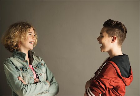 Teenage Boy and Girl looking at Each Other and Laughing, Studio Shot Stock Photo - Premium Royalty-Free, Code: 600-06752489