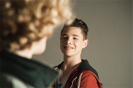 pareja heterosexual - Teenage Boy smiling at Teenage Girl, Studio Shot Foto de stock - Sin royalties Premium, Código: 600-06752492