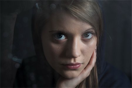 simsearch:600-06786777,k - Close-up portrait of young woman, leaning on hand, looking at camera Stock Photo - Premium Royalty-Free, Code: 600-06786763