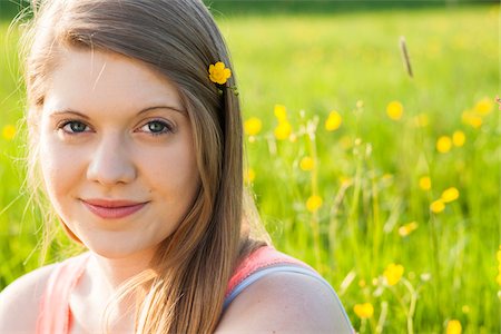 front (the front of) - Close-up portrait of young woman sitting in field with flower in hair, Germany Foto de stock - Sin royalties Premium, Código: 600-06786813