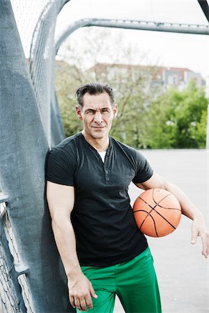 simsearch:600-06786855,k - Portrait of mature man standing on outdoor basketball court, Germany Stock Photo - Premium Royalty-Free, Code: 600-06786825