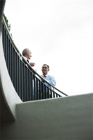 simsearch:600-03638622,k - Mature businessmen standing on outdoor balcony, talking Stock Photo - Premium Royalty-Free, Code: 600-06782199