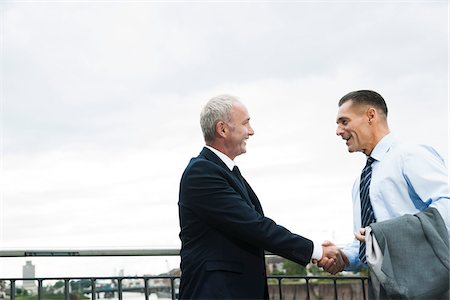 simsearch:600-06773367,k - Mature businessmen standing by railing, shaking hands outdoors, Mannheim, Germany Stock Photo - Premium Royalty-Free, Code: 600-06782202