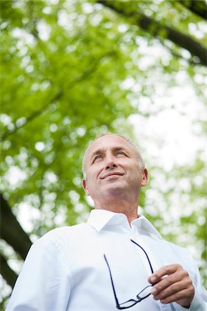 Close-up portrait of mature man holding horn-rimmed eyeglasses in park, Mannheim, Germany Fotografie stock - Premium Royalty-Free, Codice: 600-06782236