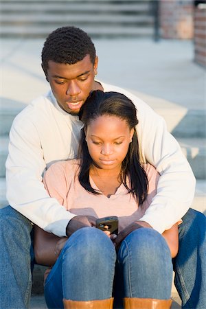 simsearch:400-05012508,k - Young couple sitting together outdoors on college campus steps, looking at smartphone, Florida, USA Foto de stock - Sin royalties Premium, Código: 600-06841934