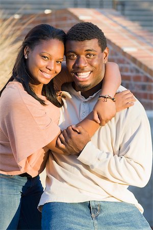 simsearch:600-06841651,k - Young couple embracing outdoors on college campus, smiling and looking at camera, Florida, USA Stock Photo - Premium Royalty-Free, Code: 600-06841930