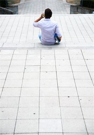 simsearch:600-07110828,k - Backview of young man sitting on steps outdoors, using cell phone, Germany Stock Photo - Premium Royalty-Free, Code: 600-06899943