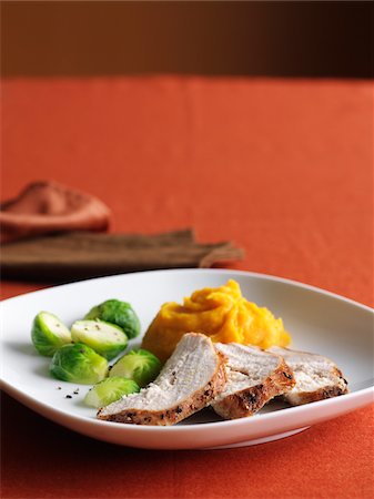 Sliced Turkey Breast with Brussels Sprouts and Mashed Sweet Potatoes for Thanksgiving Dinner on Red Background Stock Photo - Premium Royalty-Free, Code: 600-06892674