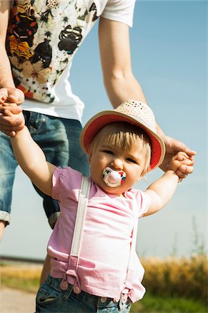 simsearch:700-06962061,k - Father Holding Baby Daughter's Hands Outdoors, Mannheim, Baden-Wurttemberg, Germany Stock Photo - Premium Royalty-Free, Code: 600-06892778