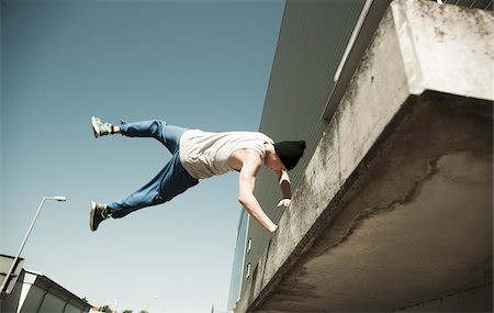 free style - Low angle view of teenaged boy doing handstand on balcony, freerunning, Germany Stock Photo - Premium Royalty-Free, Code: 600-06900010