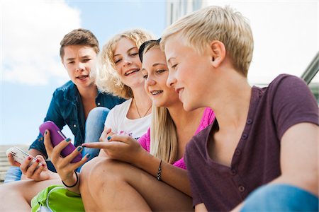 Teenagers using Cell Phones Outdoors, Mannheim, Baden-Wurttemberg, Germany Stock Photo - Premium Royalty-Free, Code: 600-06939787