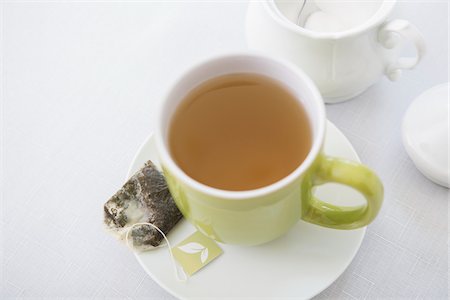 Used Tea Bag on Saucer with Cup of Tea in Green Mug with Sugar Bowl, Studio Shot Foto de stock - Sin royalties Premium, Código: 600-07066880