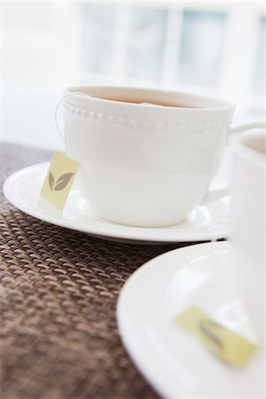 simsearch:600-07067016,k - Two white porcelain teacups with saucers and tea bags, studio shot Stock Photo - Premium Royalty-Free, Code: 600-07067020