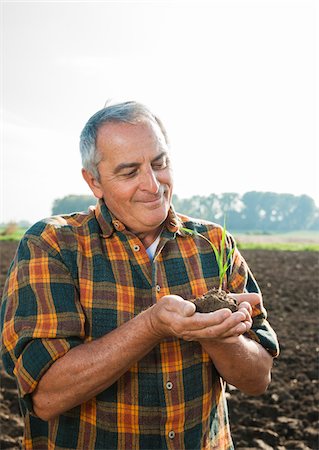 sprout - Portrait of farmer standing in field, holding seedling plant from crop, Germany Foto de stock - Sin royalties Premium, Código: 600-07148339