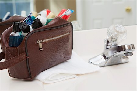 essential - Men's toiletry travel bag on bathroom counter, filled with toothbrush, lotion, razor and other grooming products, USA Stock Photo - Premium Royalty-Free, Code: 600-07199734