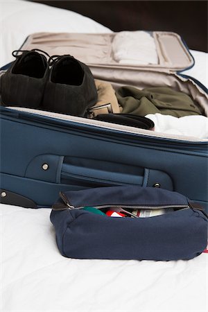 roll on luggage - Men's toiletry travel bag beside packed suitcase on bed, USA Stock Photo - Premium Royalty-Free, Code: 600-07199738