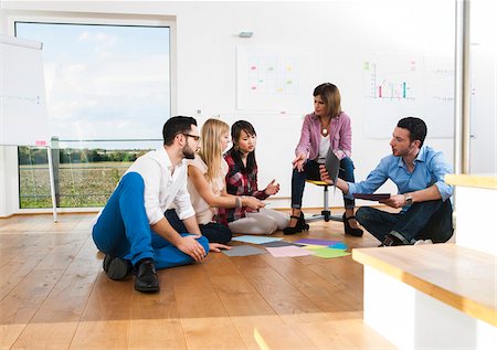 simsearch:700-07311323,k - Mature businesswoman meeting with group of young business people, sitting on floor in discussion, Germany Stock Photo - Premium Royalty-Free, Code: 600-07200043