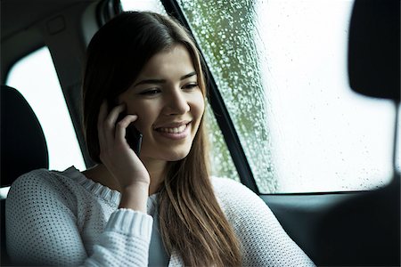 rainy window - Young woman sitting inside car and talking on cell phone, on overcast day, Germany Stock Photo - Premium Royalty-Free, Code: 600-07278934