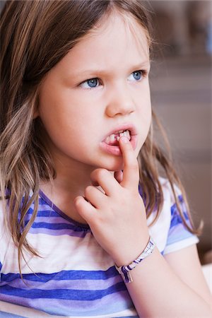 Close-up of Girl Playing with Loose Tooth Stock Photo - Premium Royalty-Free, Code: 600-07363884