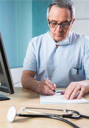 simsearch:700-07529229,k - Doctor with Sugical Mask doing Paperwork Stock Photo - Premium Royalty-Free, Code: 600-07487604