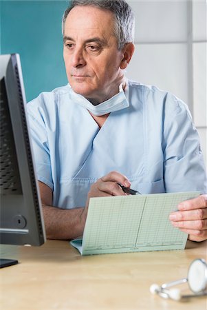 Doctor with Sugical Mask at Computer Stock Photo - Premium Royalty-Free, Code: 600-07487603