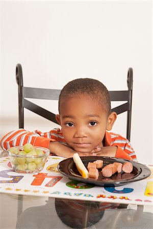 sad child sitting - Boy Unhappy with his Lunch at Kitchen Table Stock Photo - Premium Royalty-Free, Code: 600-07529169