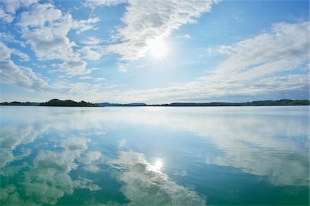 simsearch:600-08916150,k - Blue sky, clouds and sun reflected in lake, Lake Woerthsee, Bavaria, Germany Stock Photo - Premium Royalty-Free, Code: 600-07784609