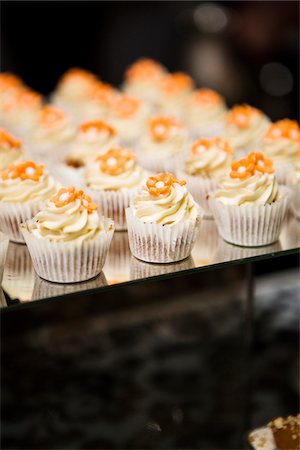 simsearch:600-07067653,k - Close-up of Cupcakes with Orange Icing Flowers on Dessert Table Stock Photo - Premium Royalty-Free, Code: 600-07991667